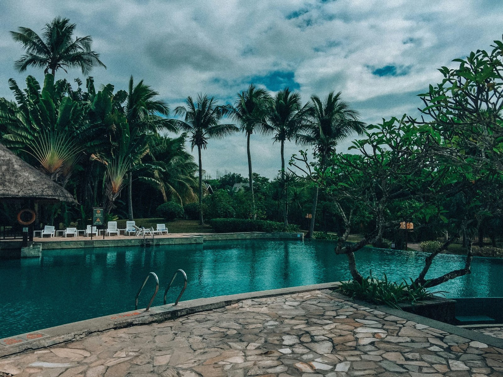 a pool with a stone walkway next to it